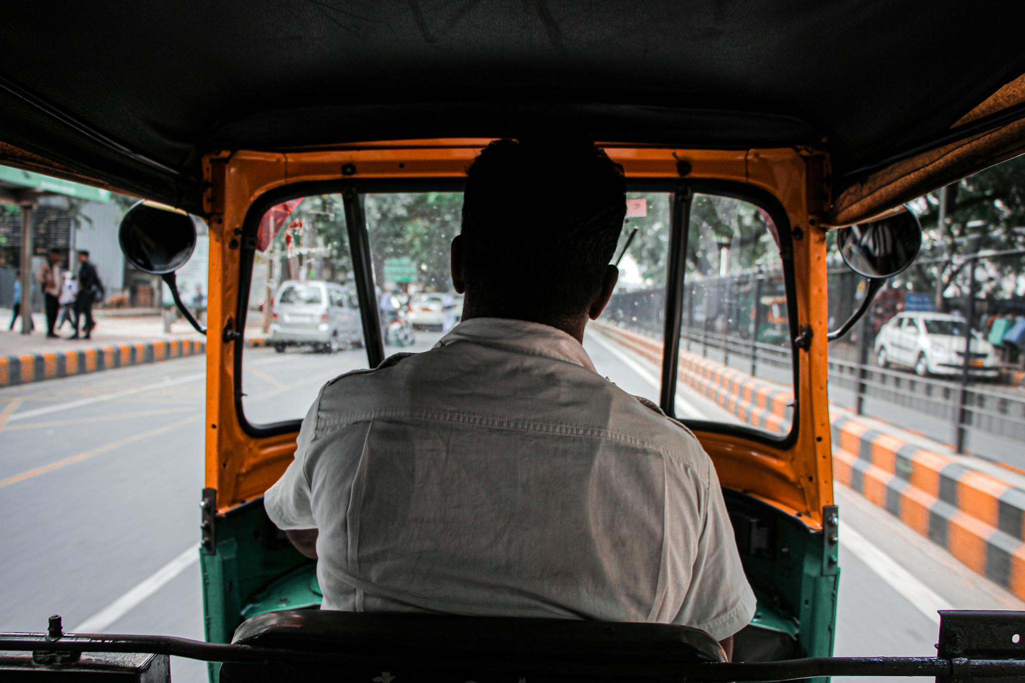 Experience the vibrant city life from the backseat of an auto rickshaw, capturing the essence of urban transport.